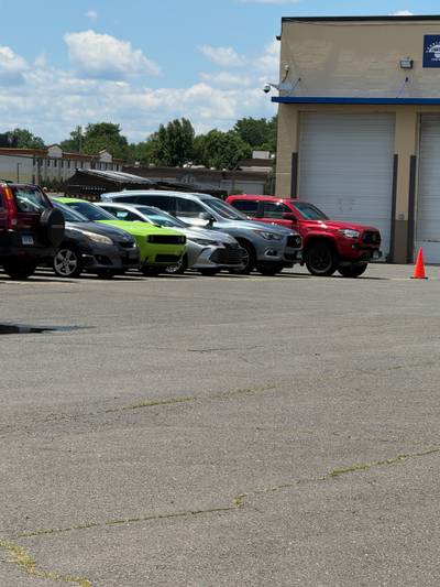 Cracked asphalt parking lot with vehicles