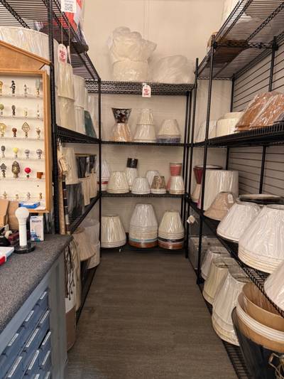 Wire shelving stacked with wrapped lampshades
