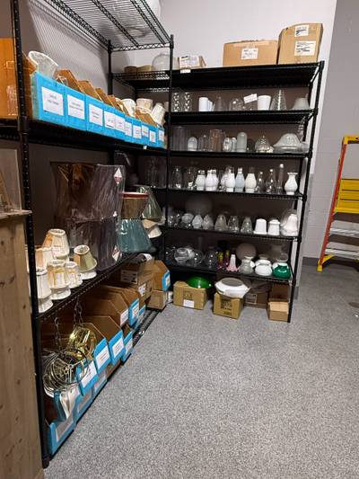 Wire shelving stacked with glass lampshades globes