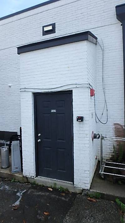 Rear exterior metal door with exposed conduit