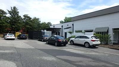 Rear drive and dumpster enclosure, patched asphalt with minor surface cracking