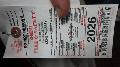 Omni Fire & Safety extinguisher inspection tag, punched 2026 expiration