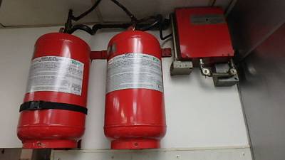 Wall-mounted wet-chemical suppression cylinders with piping and actuation control