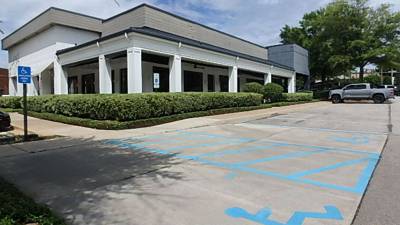 Accessible parking spaces and signage at covered walkway corner